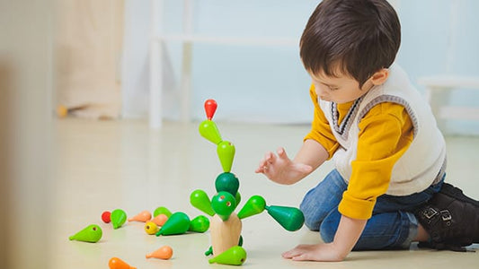 Niño pequeño jugando con juguetes educativos en casa apoyando el desarrollo infantil de 0 a 6 años