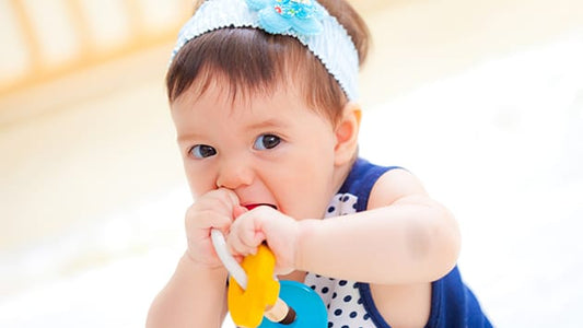 Bebé mordiendo un juguete educativo en la etapa del desarrollo infantil de 0 a 6 años