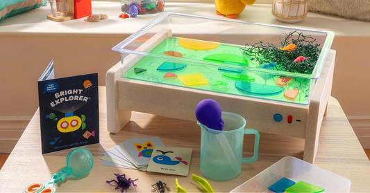 Mesa de juego sensorial con agua y objetos coloridos para estimular los beneficios del juego sensorial en niños