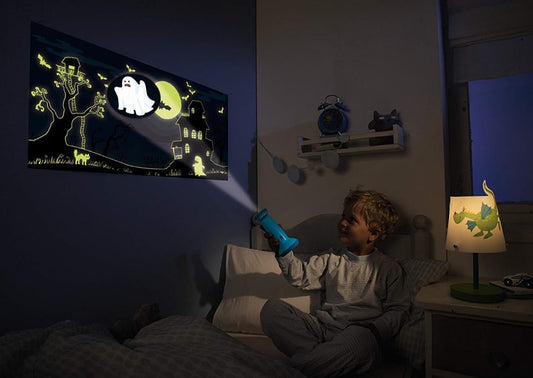 Niño usando linterna en su habitación para aprender cómo superar el miedo a la oscuridad