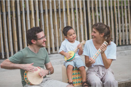 Familia con juguetes musicales para desarrollo infantil fomentando aprendizaje y conexión emocional con instrumentos